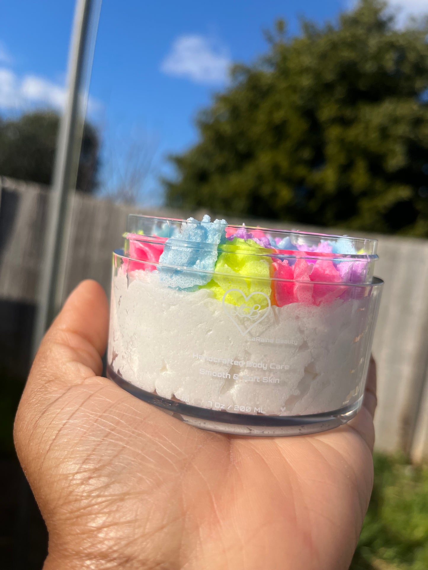 white shimmer base with multi colour flower top body scrub, floral fruity body exfoliant. A foaming/cleansing and exfoliating gentle body scrub to achieve smooth soft skin. UK handmade Vegan skincare that brings a fun luxurious experience to self care and shower routines. Scrub and get rid of patchy dry skin, clogged pores and ingrown hairs. The best body scrub you could ever ask for.