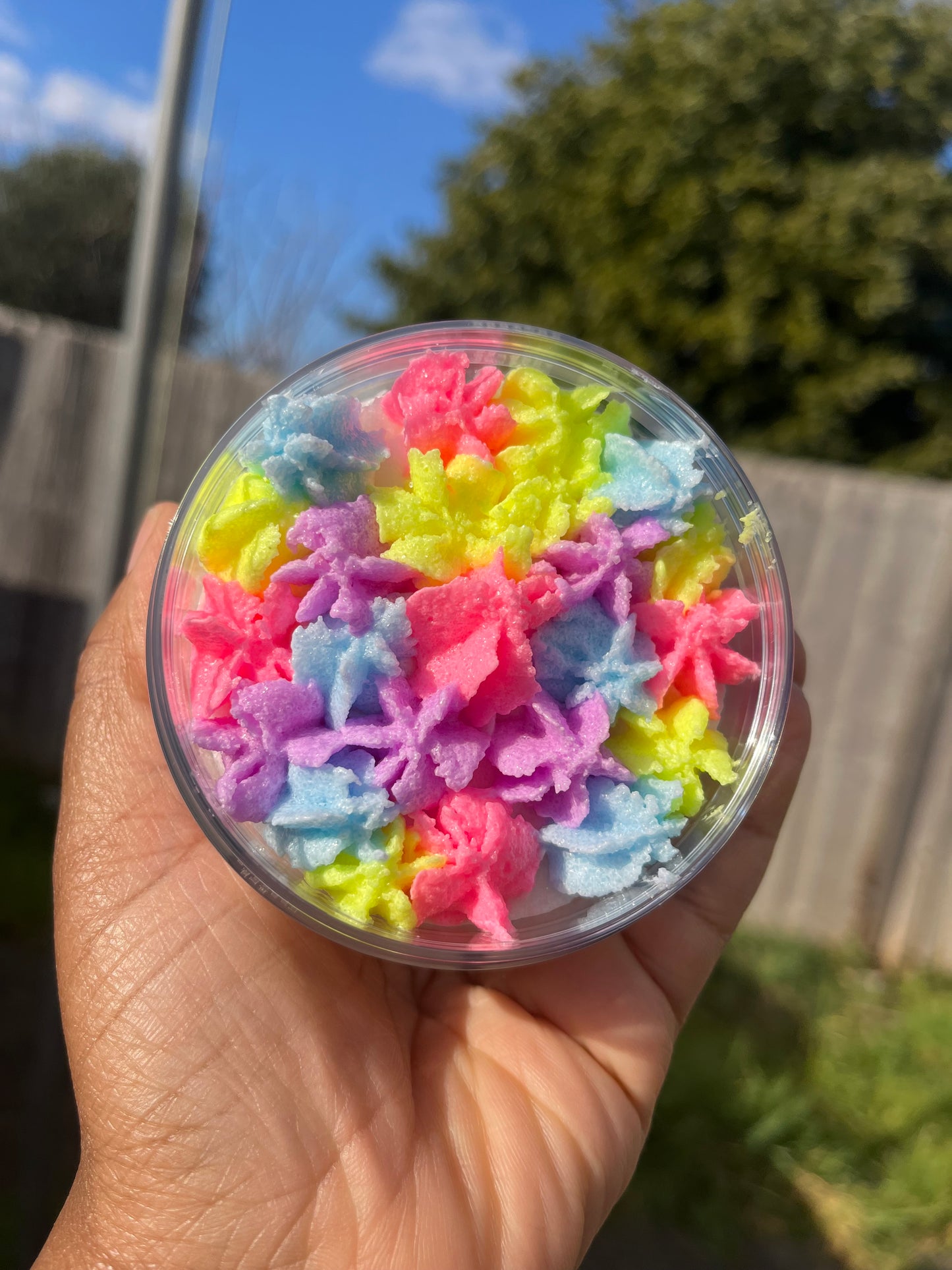 white shimmer base with multi colour flower top body scrub, floral fruity body exfoliant. A foaming/cleansing and exfoliating gentle body scrub to achieve smooth soft skin. UK handmade Vegan skincare that brings a fun luxurious experience to self care and shower routines. Scrub and get rid of patchy dry skin, clogged pores and ingrown hairs. The best body scrub you could ever ask for.