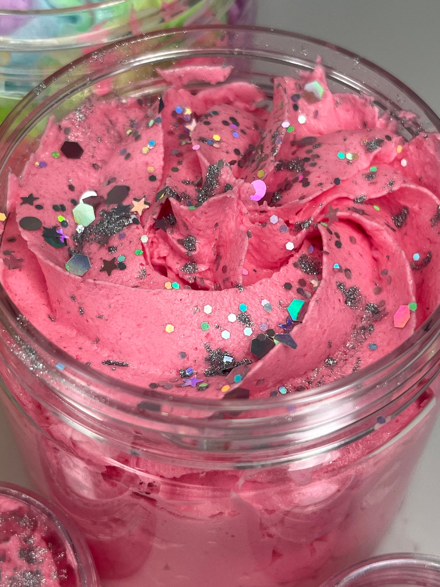 Deep pink/ red crimson cranberry scented whipped soap / shave butter topped with silver glitter. They turn your daily cleanse into a spa-like treat. Light, airy, and decadently whipped, our soaps are designed to cleanse, soften, and leave your skin feeling fresh and nourished. Use them as a body wash, shaving cream, or bath-time indulgence—they’re as versatile as they are luxurious.